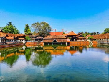 A serene view of Ambalapuzha Krishna Temple, showcasing traditional Kerala architecture and lush surroundings.