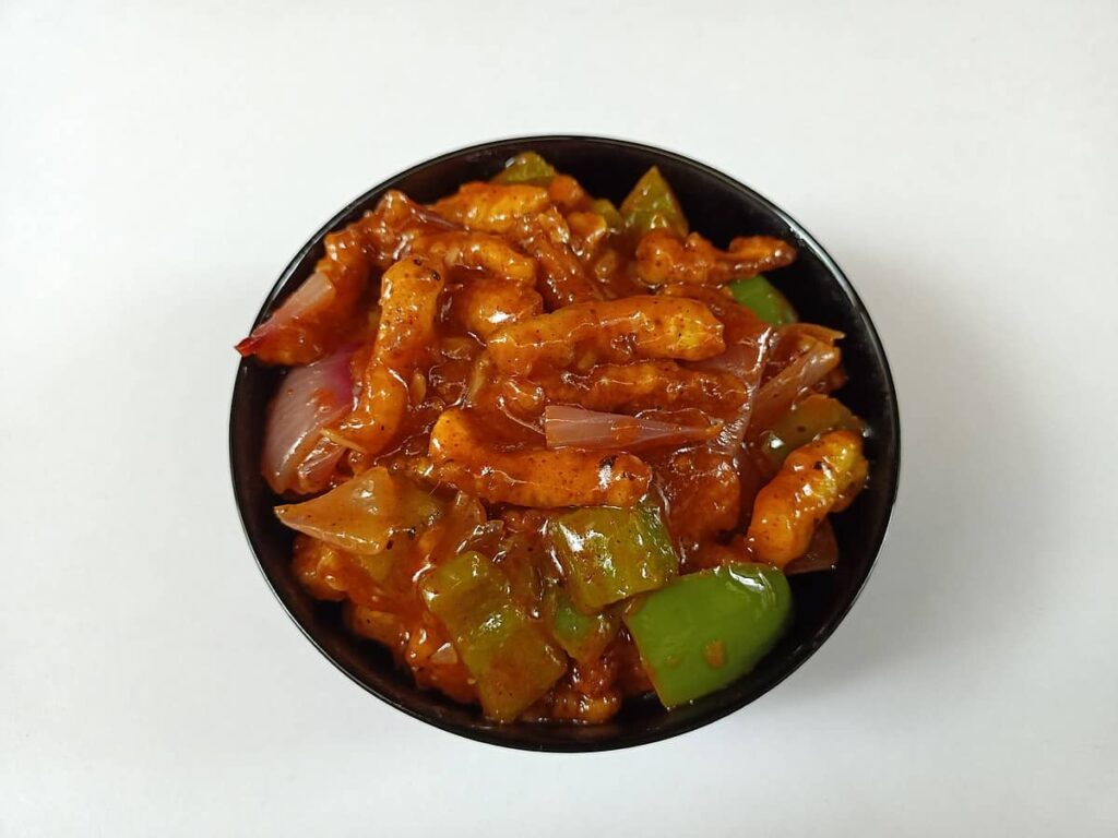 Crispy baby corn tossed in a sweet and spicy honey chilli sauce, garnished with fresh cilantro.