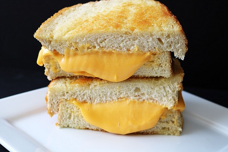 A crispy cheese grilled sandwich with melted cheese oozing between golden-brown toasted bread slices.
