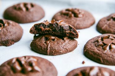 Freshly baked chocolate chip cookie with melted chocolate chunks, golden edges, and a soft, chewy center, placed on a cooling rack.