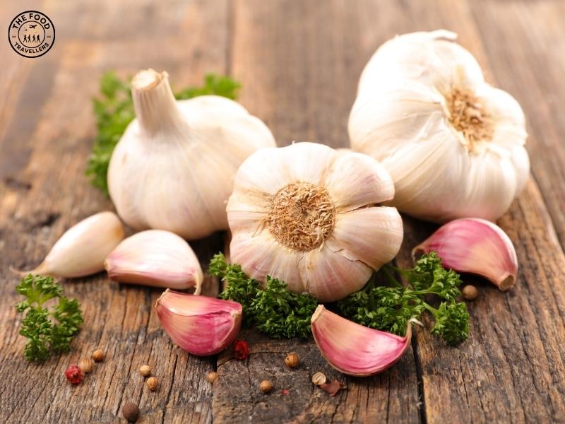 Close-up of fresh garlic bulbs with cloves, showcasing its natural texture and layers. Learn about the health benefits and culinary uses of garlic.