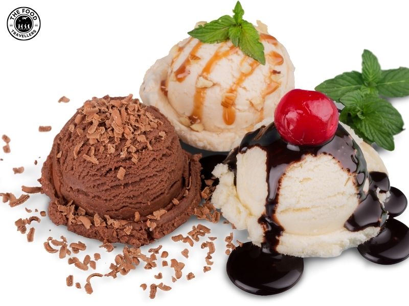A scoop of creamy ice cream in a cone, topped with chocolate sauce and sprinkles.