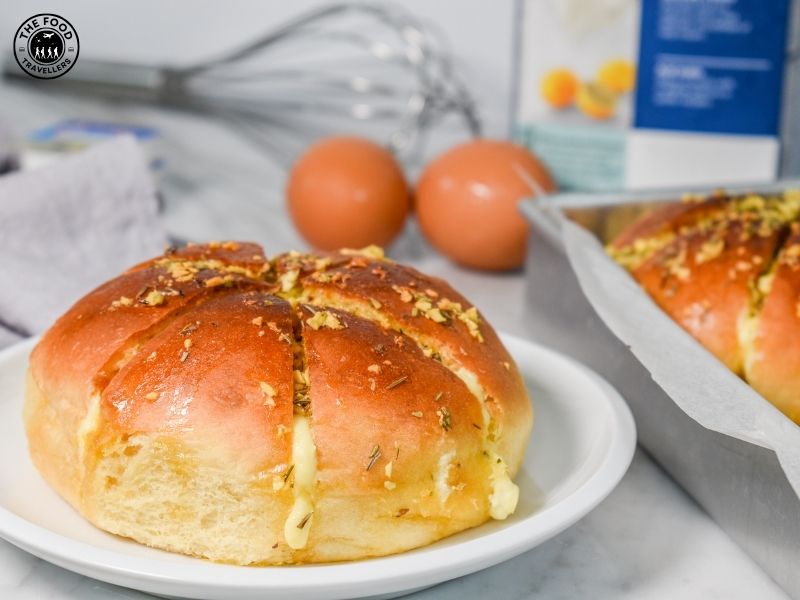 Close-up of Korean cream cheese garlic bread, featuring a golden crust, creamy filling, and a glossy garlic butter coating.