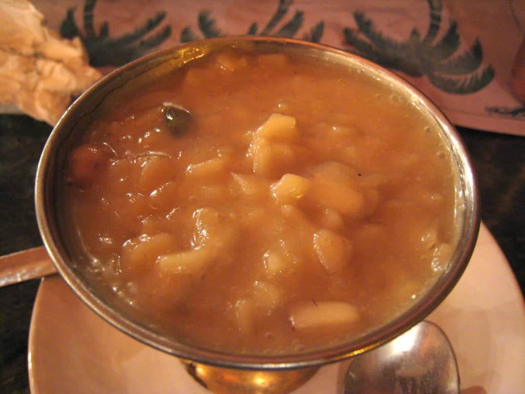 A bowl of creamy Palada Payasam, a traditional Kerala dessert made with rice ada, milk, and sugar, garnished with cashews and raisins.