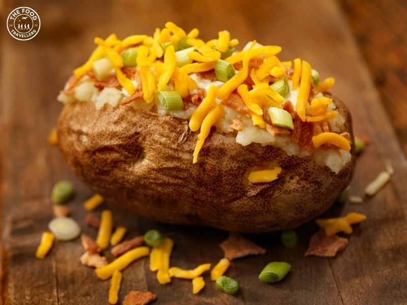 A perfectly baked potato, golden and crispy on the outside, with a fluffy, soft interior, garnished with herbs and a dollop of sour cream.A perfectly baked potato, golden and crispy on the outside, with a fluffy, soft interior, garnished with herbs.