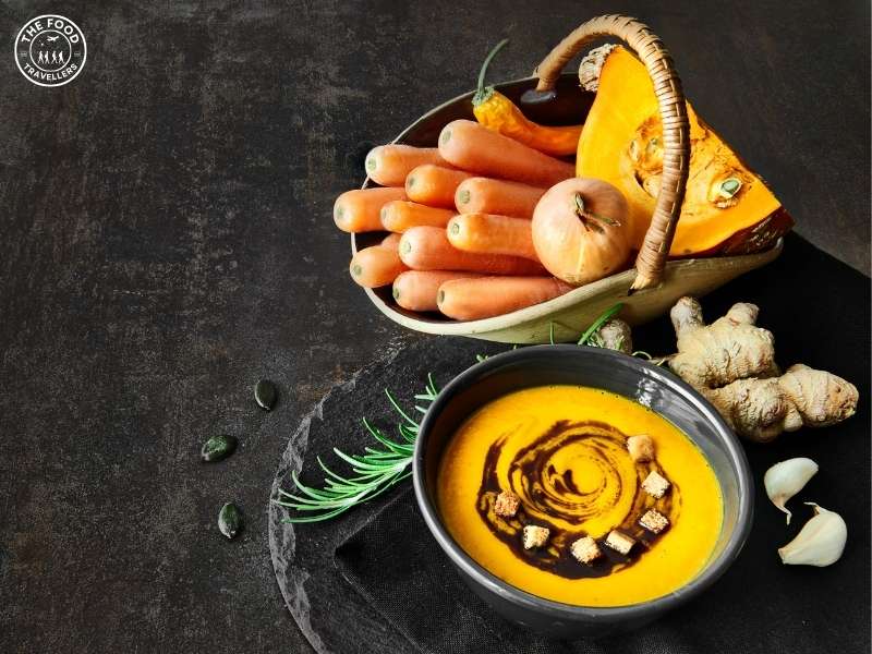 A bowl of smooth Carrot Ginger Soup, featuring vibrant orange puree, ginger hints, and a sprinkle of herbs for added flavor.