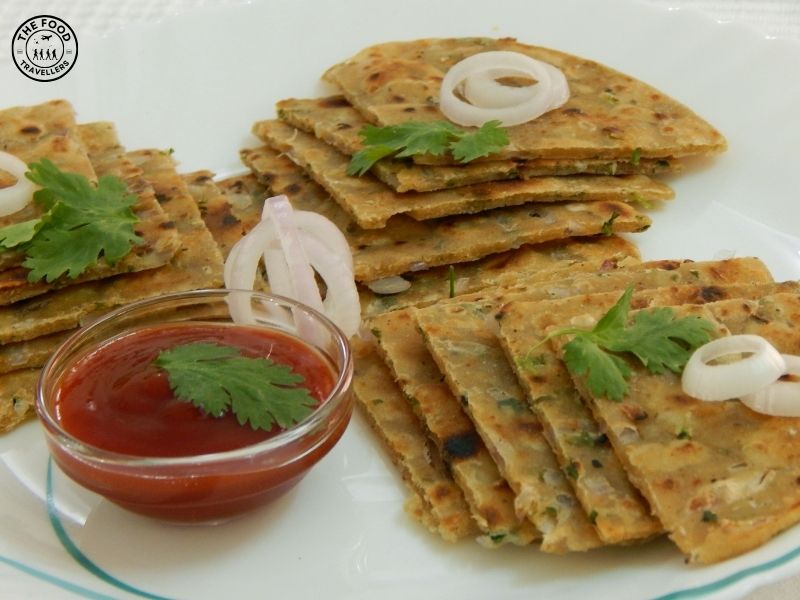 "Top view of a crispy, golden-brown crunchy Pyaz Paratha, layered with a spiced onion filling.