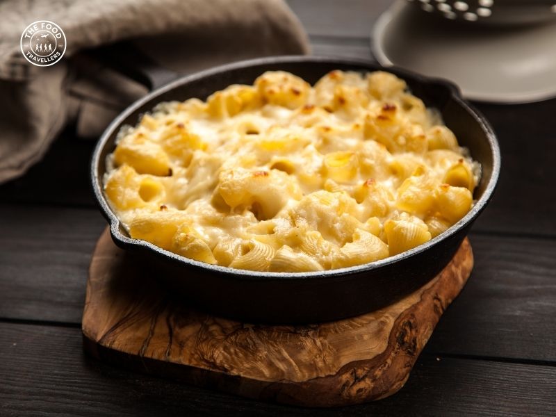 A delicious bowl of Veg Mac and Cheese, featuring creamy cheese sauce, pasta, and a variety of colorful vegetables.