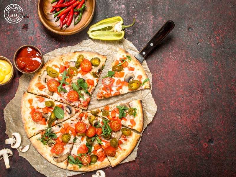 Mexican Green Wave Pizza with vibrant green sauce, fresh toppings, and a spicy garnish.
