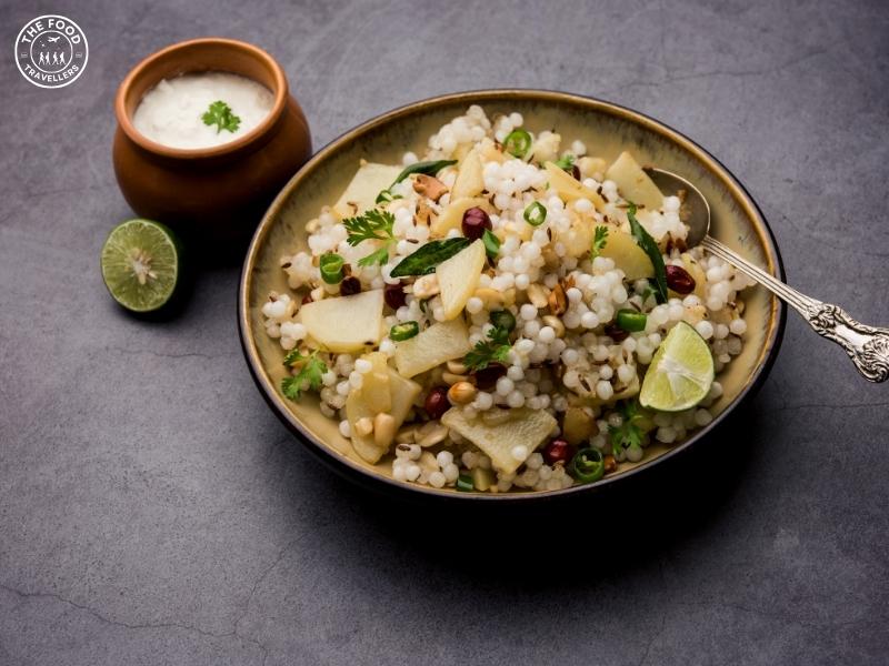 A plate of Sabudana Khichdi served with a side of sweet curd, garnished with fresh cilantro, featuring tapioca pearls, potatoes, and spices.
