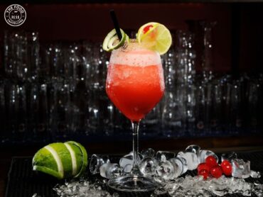 A refreshing Strawberry Daiquiri garnished with a fresh strawberry and lime slice, served in a chilled glass.