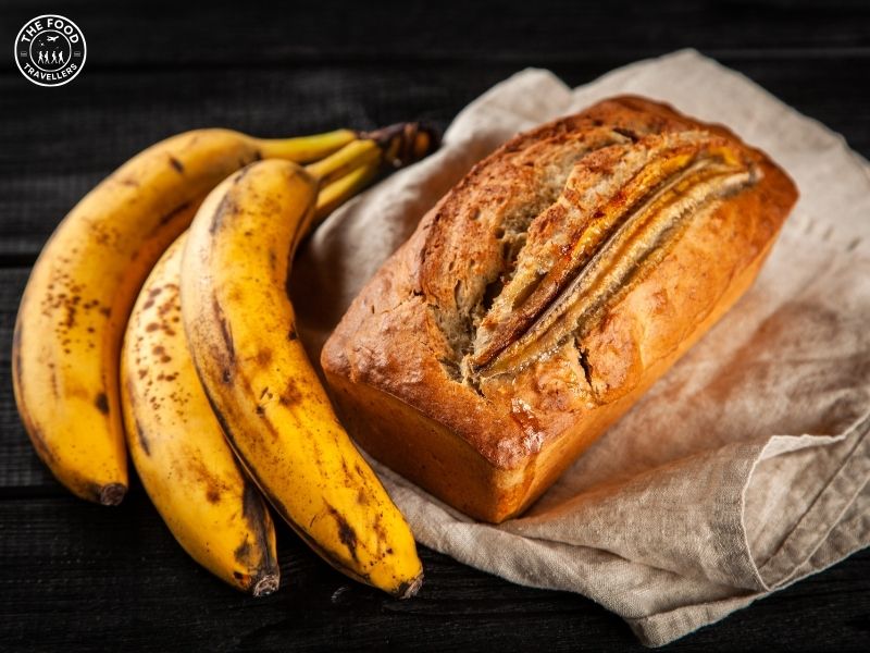 A freshly baked loaf of Veg Banana Bread, showcasing its golden-brown crust and moist, textured interior.