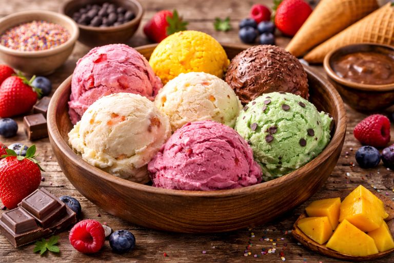 Bowl of ice cream with different flavors including strawberry, chocolate, vanilla, mango, and mint chocolate chip.