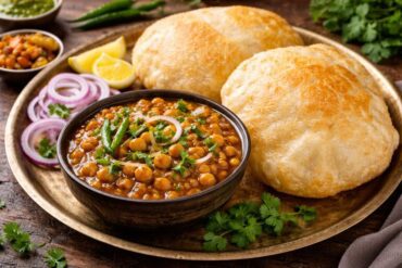 Chole Bhature recipe with two fluffy bhature and a bowl of spicy chickpea curry garnished with coriander
