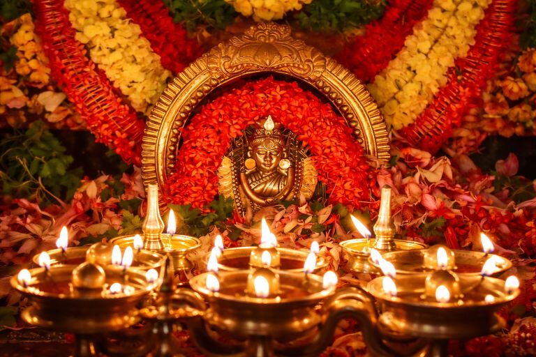 Kadampuzha Bhagavathy temple altar with brass lamps and flower decorations during pooja in Kerala