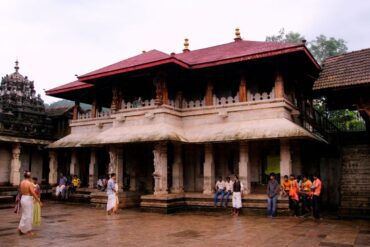 Kollur Mookambika Temple in Karnataka with traditional Kerala-style architecture and devotees in the temple courtyard