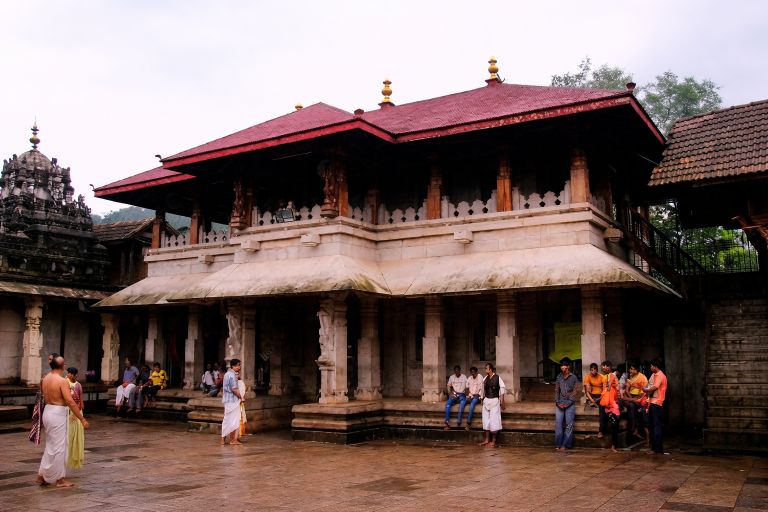 Kollur Mookambika Temple in Karnataka with traditional Kerala-style architecture and devotees in the temple courtyard