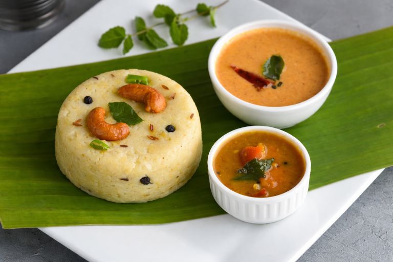 Ven Pongal served on a banana leaf with coconut chutney and sambar