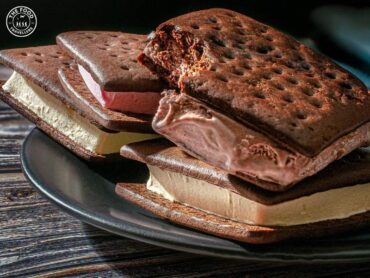 "Close-up of a deliious Oreo Chocolate Ice Cream Sandwich with a thick layer of creamy ice cream between two chocolatey Oreo cookies.