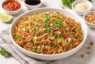 Mumbai Style Chinese Bhel Recipe served in a white bowl with crispy noodles, fresh vegetables, peanuts, and coriander garnish