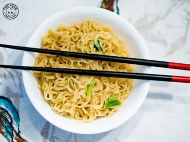 An illustration depicting the invention of ramen, with a bowl of noodles and various ingredients, symbolizing the creation of this iconic Japanese dish.