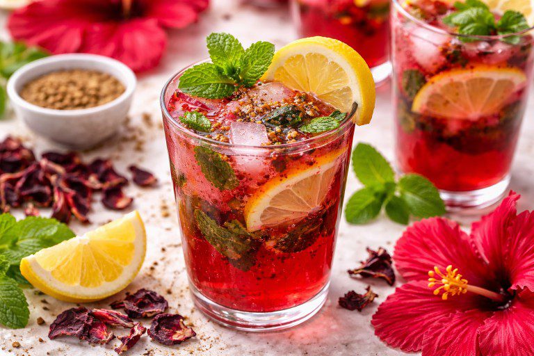 Hibiscus Masala Splash mocktail with fresh hibiscus flowers, mint, lemon, and sparkling soda