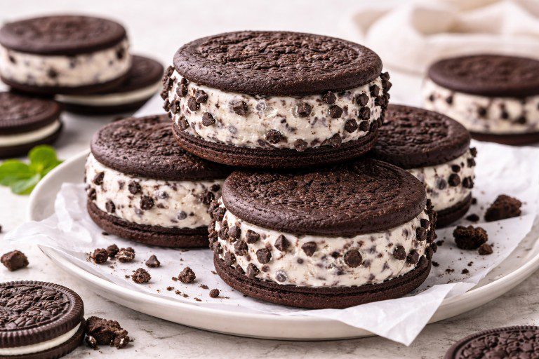Oreo chocolate ice cream sandwich rolled in mini chocolate chips on a white plate