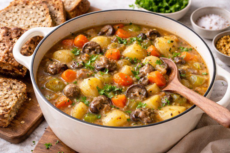 Hearty veg Irish stew with potatoes, carrots, mushrooms, and parsley in a rustic pot