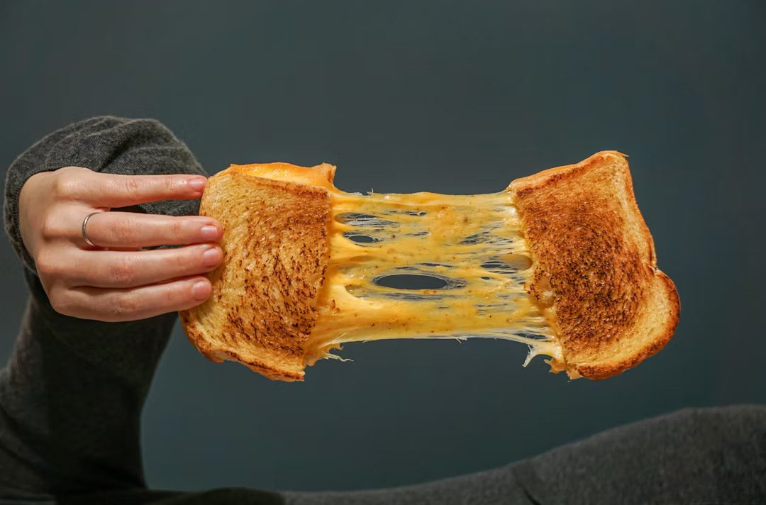 Crispy grilled cheese sandwich with melted cheese between golden toasted bread.