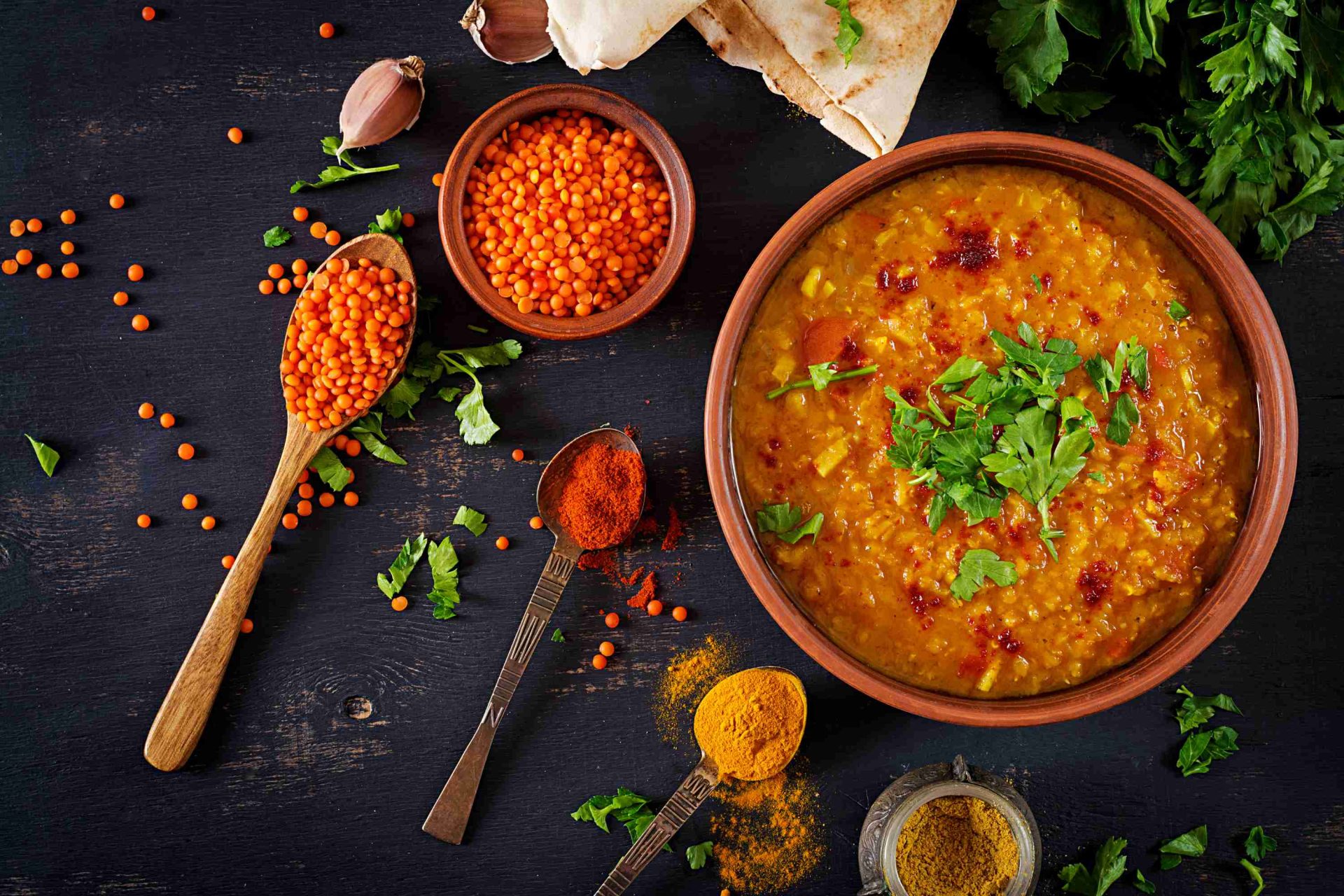 Steaming South Indian sambar served with dosa, idli and mini idli on banana leaf