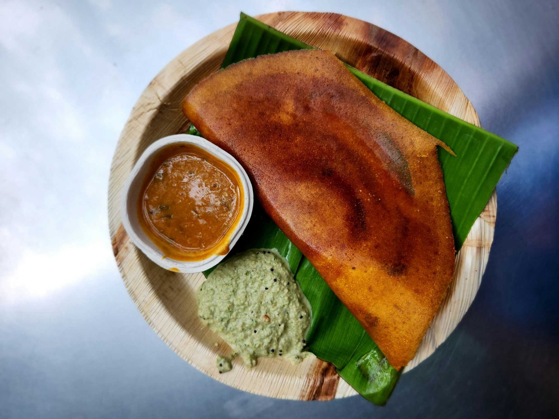 Mysore masala dosa with spicy red chutney and potato filling served with coconut chutney and sambar
